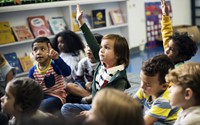 Child raising hand in classroom